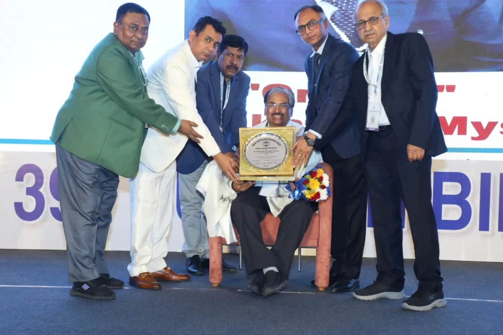 Dr. Venkataram Mysore being honoured with the Amar Kanth Jha Oration plaque at the IADVL Bihar CUTICON 2025 on stage in Puri
